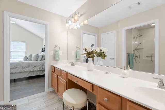 a en suite bathroom with a double vanity sink and a mirror