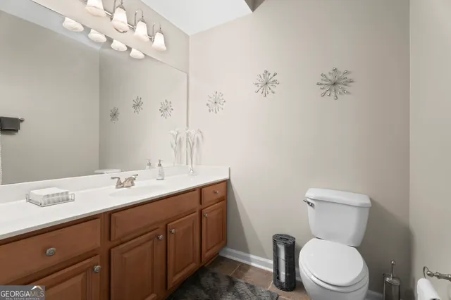 a bathroom with a toilet sink and mirror