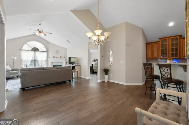 a living room with furniture kitchen view and a chandelier