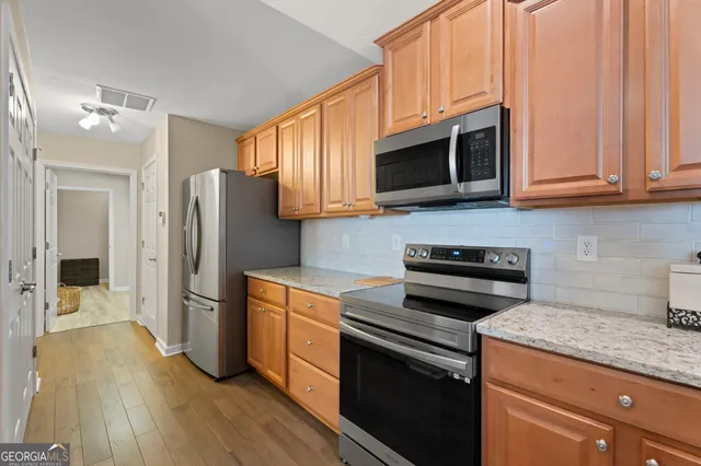 a kitchen with stainless steel appliances granite countertop a stove microwave and refrigerator