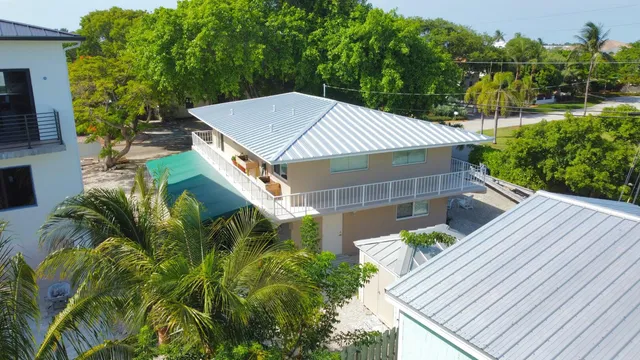 an aerial view of a city with lots of residential buildings ocean and mountain view in back