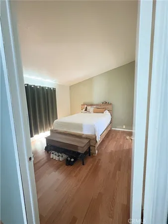 a bedroom with a bed and wooden floor