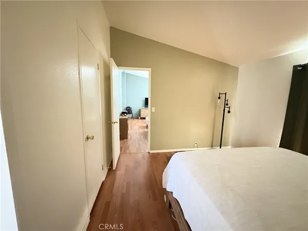 a bedroom with a bed and wooden floor