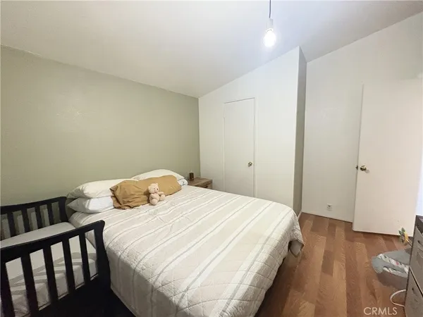 a bedroom with a bed and wooden floor