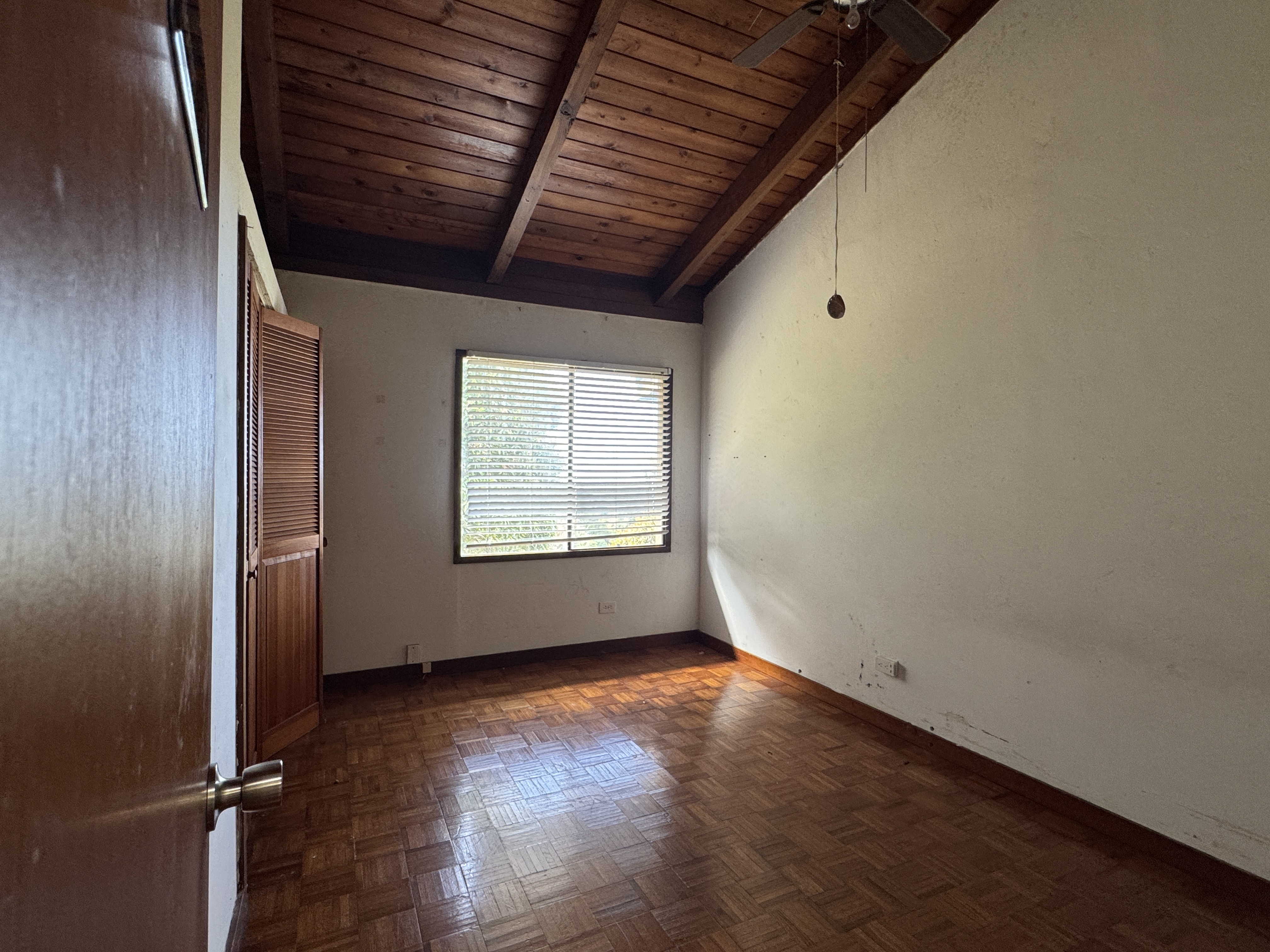 84-5040 Hawaiʻi Belt Road Captain Cook, HI 96704 - Photo 12 of 30 an empty room with wooden floor and windows