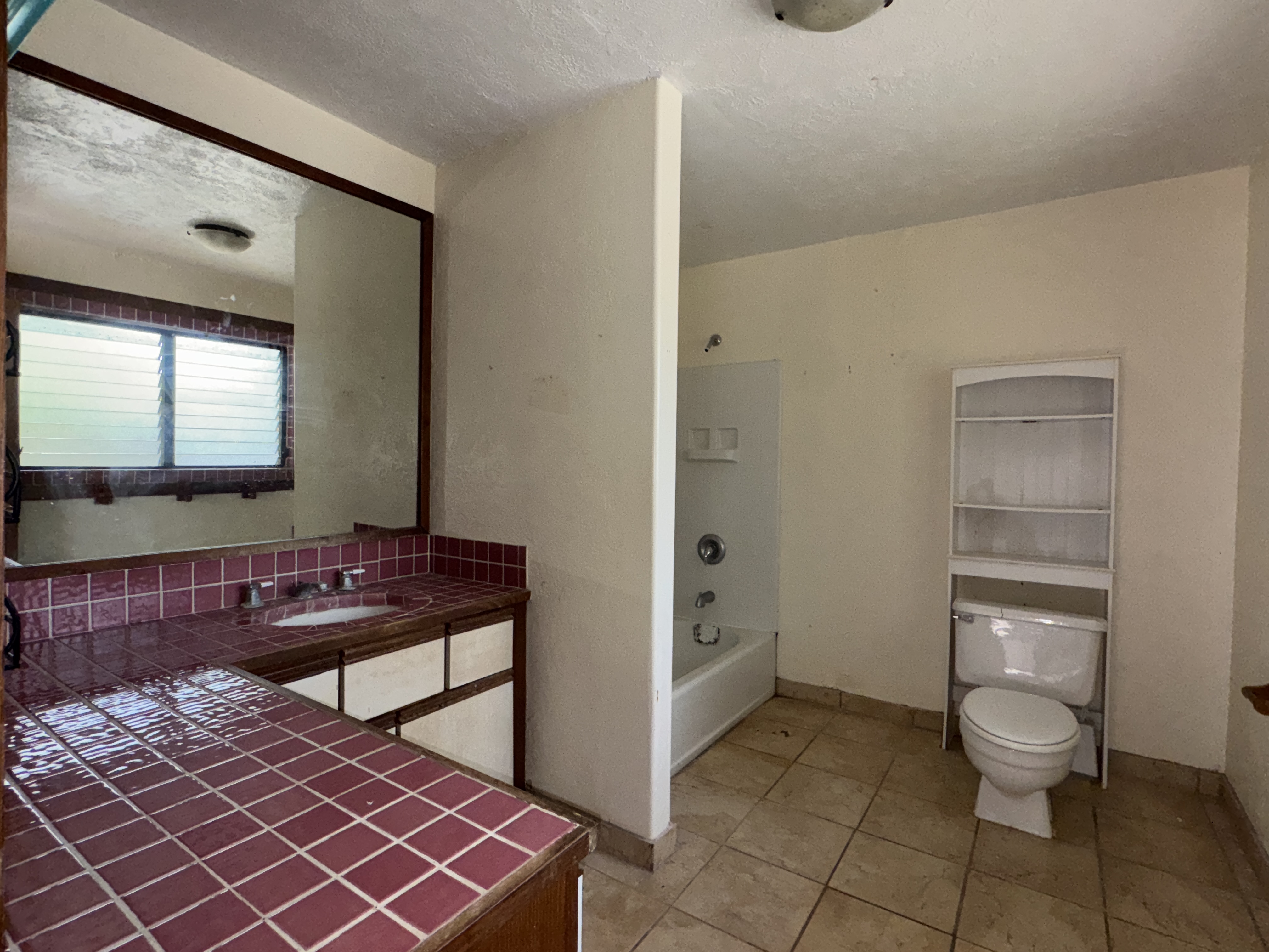 84-5040 Hawaiʻi Belt Road Captain Cook, HI 96704 - Photo 21 of 30 a bathroom with a toilet a sink and a mirror