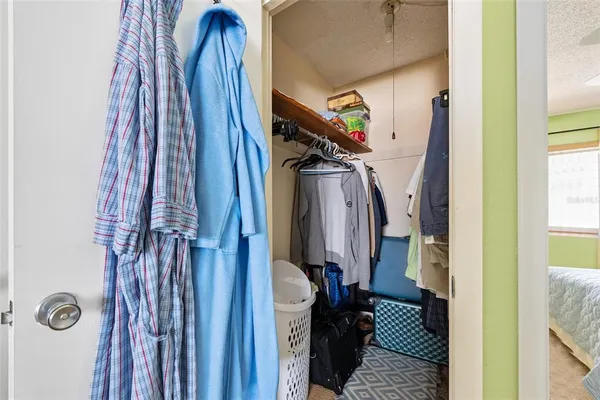a view of walk in closet with clothes and shoes