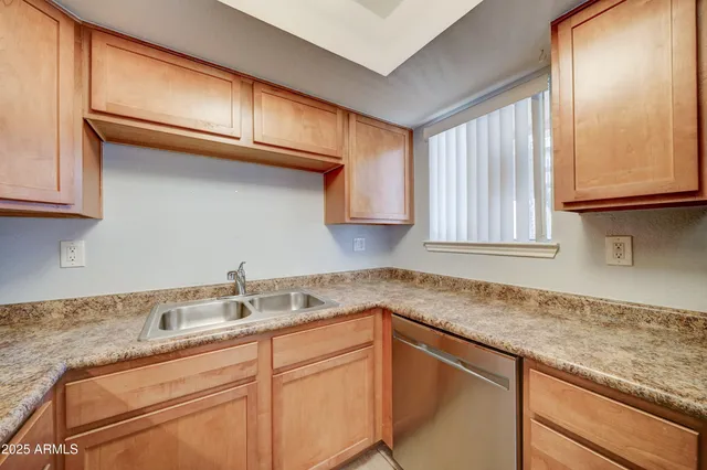 a kitchen with stainless steel appliances granite countertop white cabinets and a stove top oven