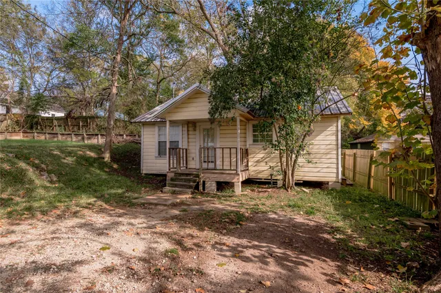 a white house that has a tree in front of it
