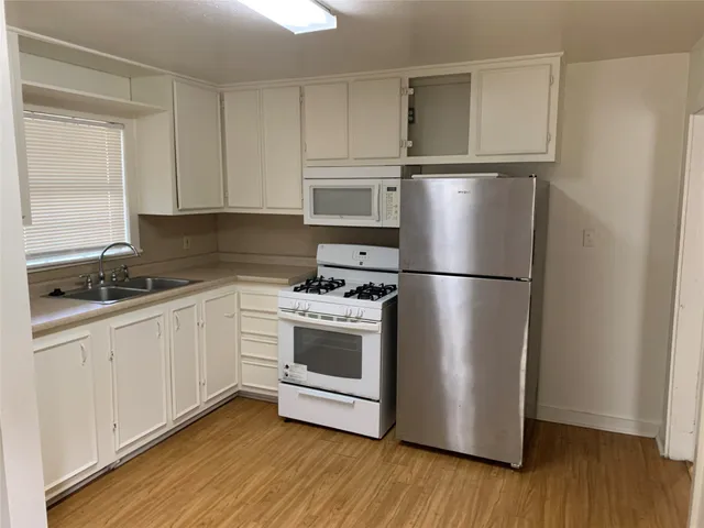 a kitchen with a refrigerator stove and wooden cabinets