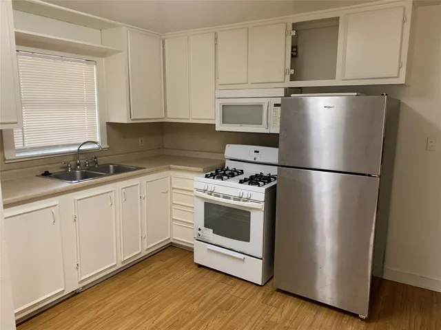 a kitchen with a refrigerator sink and cabinets
