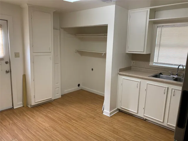 a view of a kitchen with wooden floor and electronic appliances