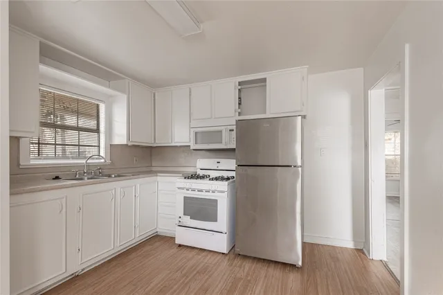 a kitchen with stainless steel appliances a refrigerator sink and cabinets