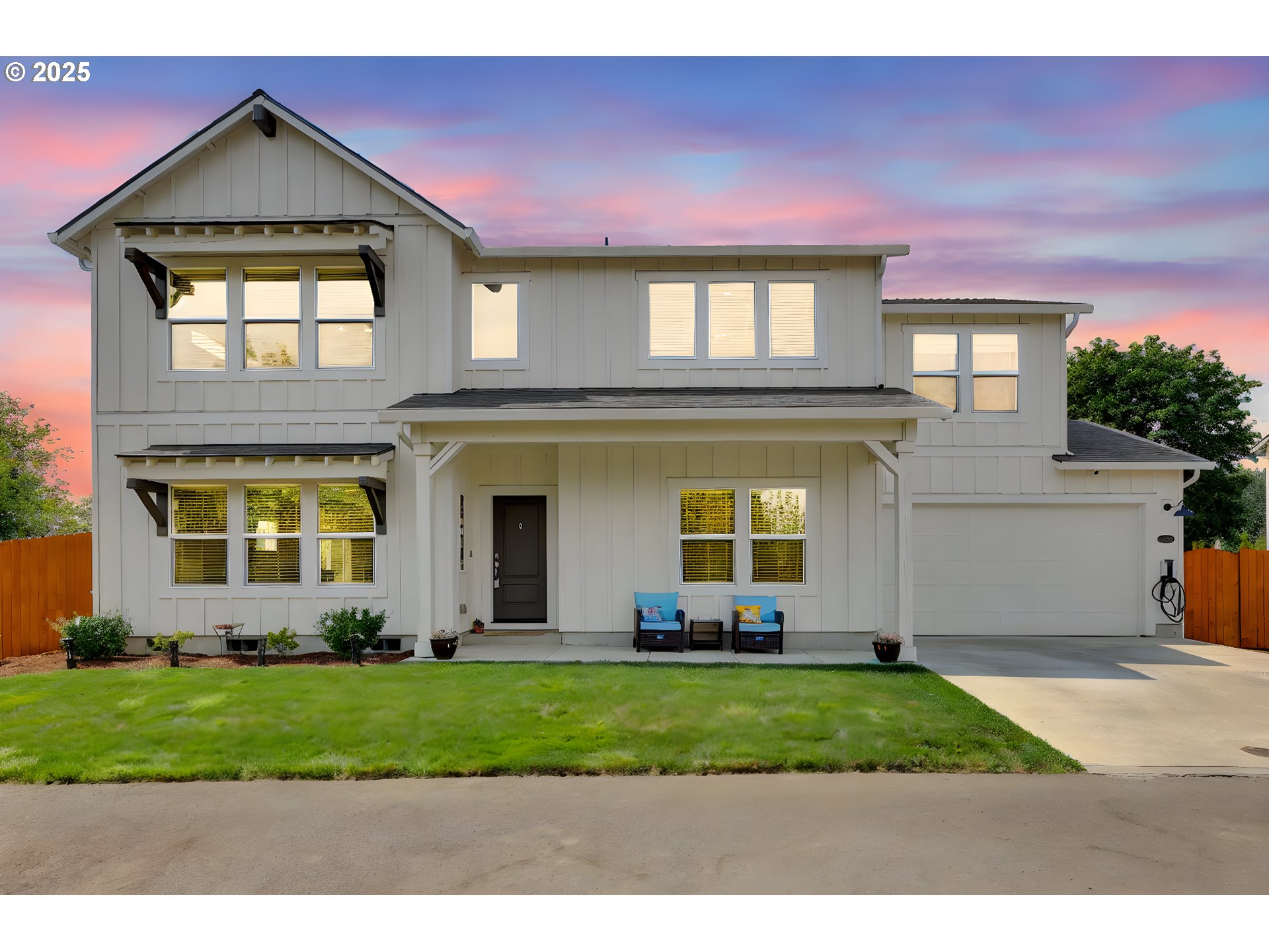 a front view of a house with a yard and potted plants