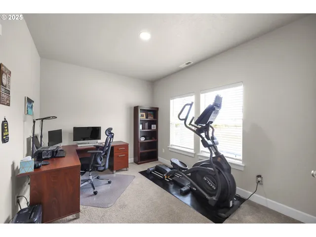 a view of a workspace with furniture and a window