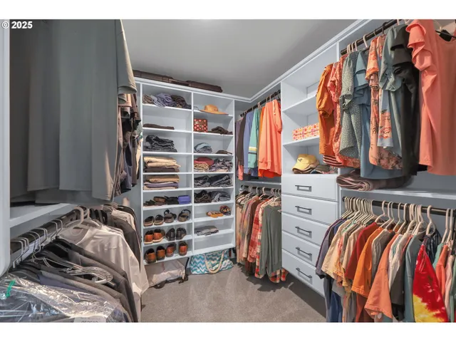 a view of walk in closet with clothes and shoes