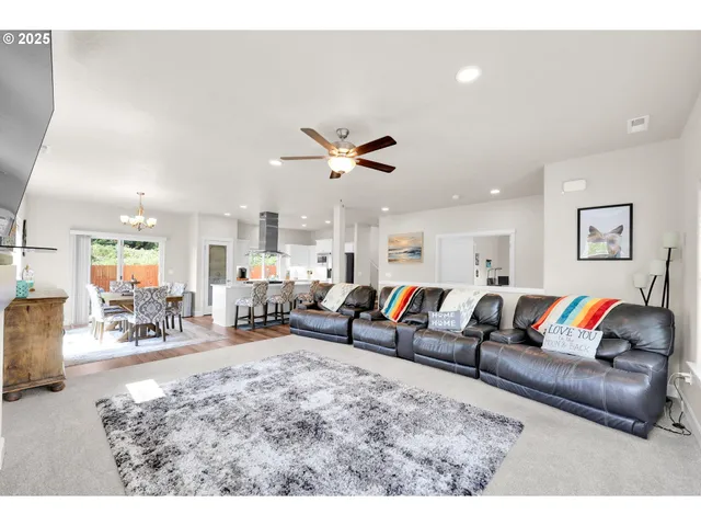 a living room with furniture kitchen view and a potted plant