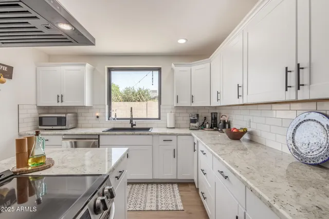 a kitchen with appliances a sink and cabinets