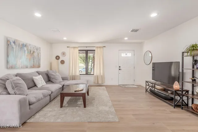 a living room with furniture a dining table and a flat screen tv