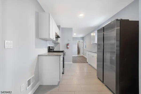 a kitchen with stainless steel appliances granite countertop white cabinets and a stove