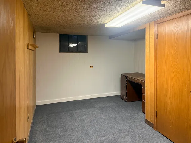 a view of an empty room with a fireplace and a window