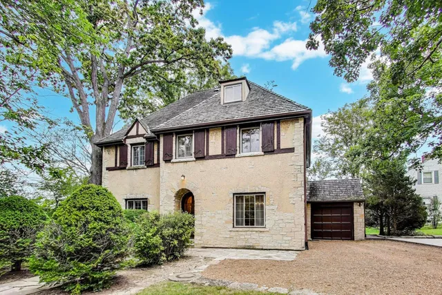 a front view of a house with a tree