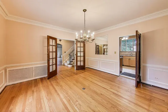 a view of a livingroom with wooden floor and a kitchen space