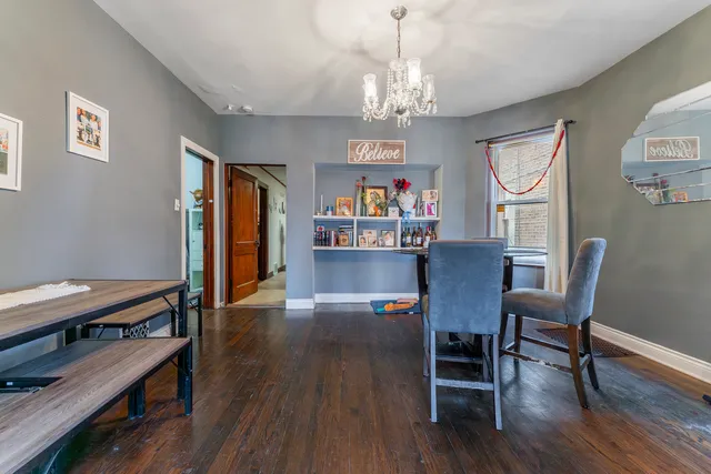 a view of a dining room with furniture a chandelier and wooden floor