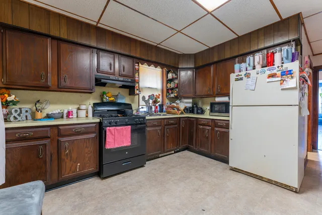 a kitchen with granite countertop stainless steel appliances a refrigerator and a sink