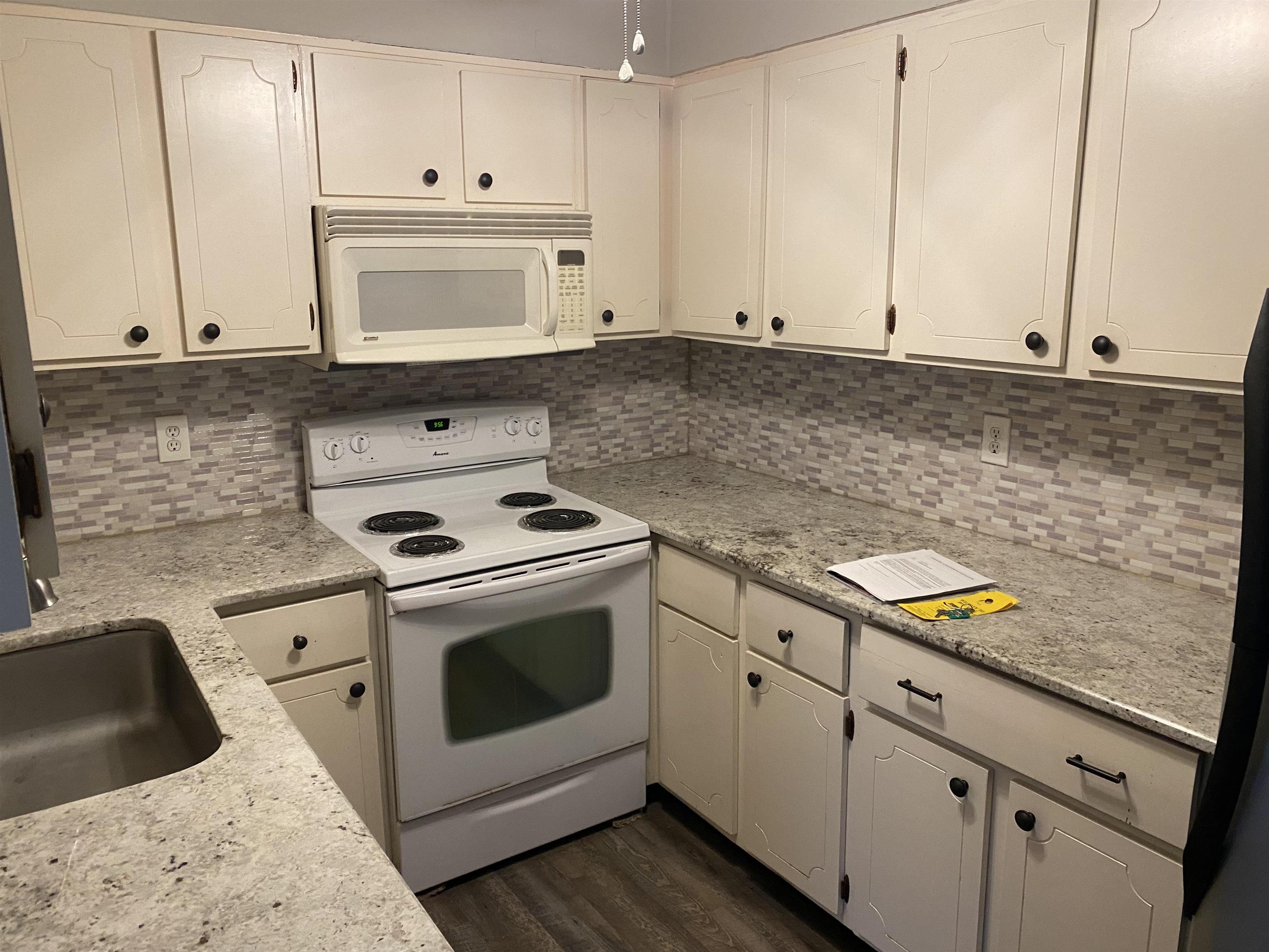 5696 Quince Road, Unit 7 Memphis, TN 38119 - Photo 9 of 15 a kitchen with granite countertop white cabinets and white appliances