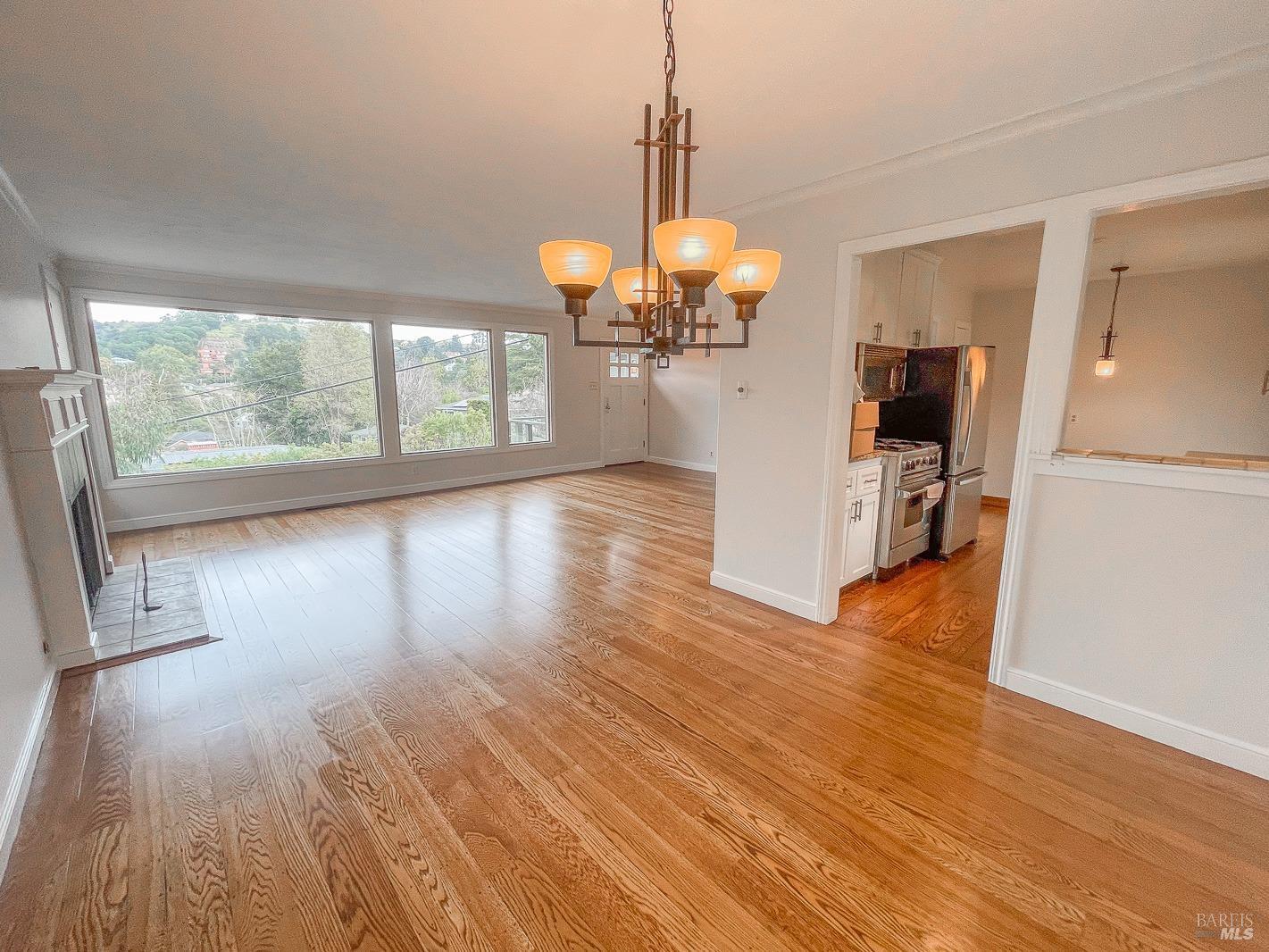 112 Reed Boulevard Mill Valley, CA 94941 - Photo 16 of 39 a view of a room with wooden floor a ceiling fan and windows