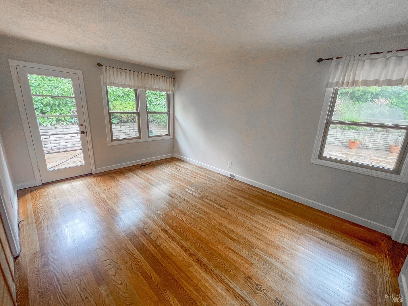 112 Reed Boulevard Mill Valley, CA 94941 - Photo 21 of 39 a view of an empty room with wooden floor and a window