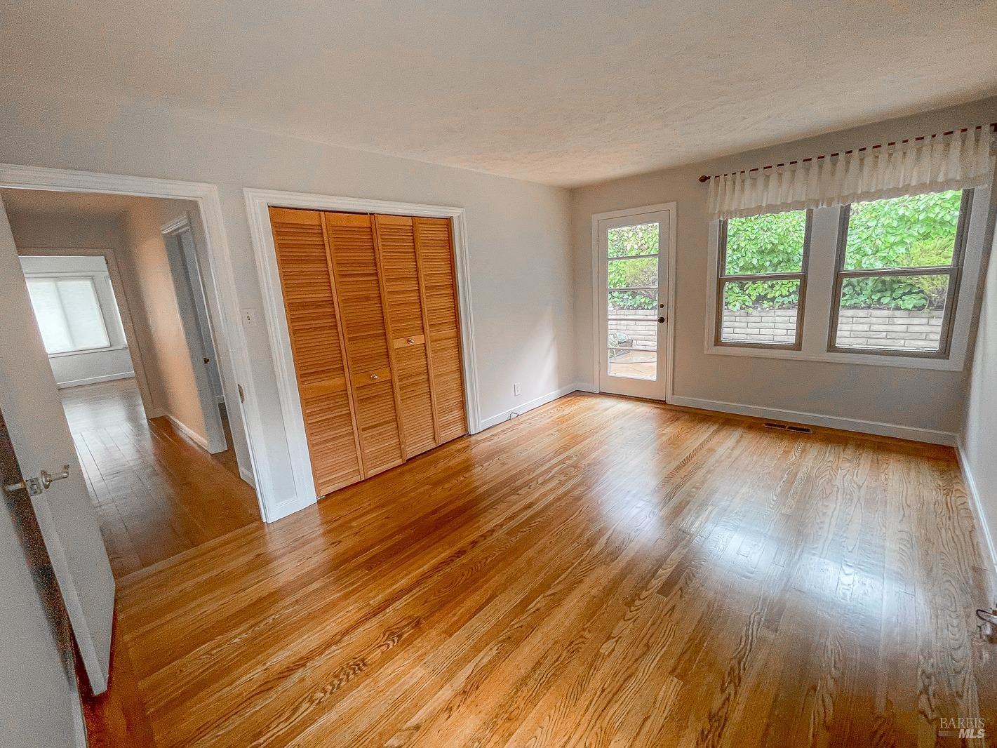 112 Reed Boulevard Mill Valley, CA 94941 - Photo 22 of 39 a view of an empty room with wooden floor and a window