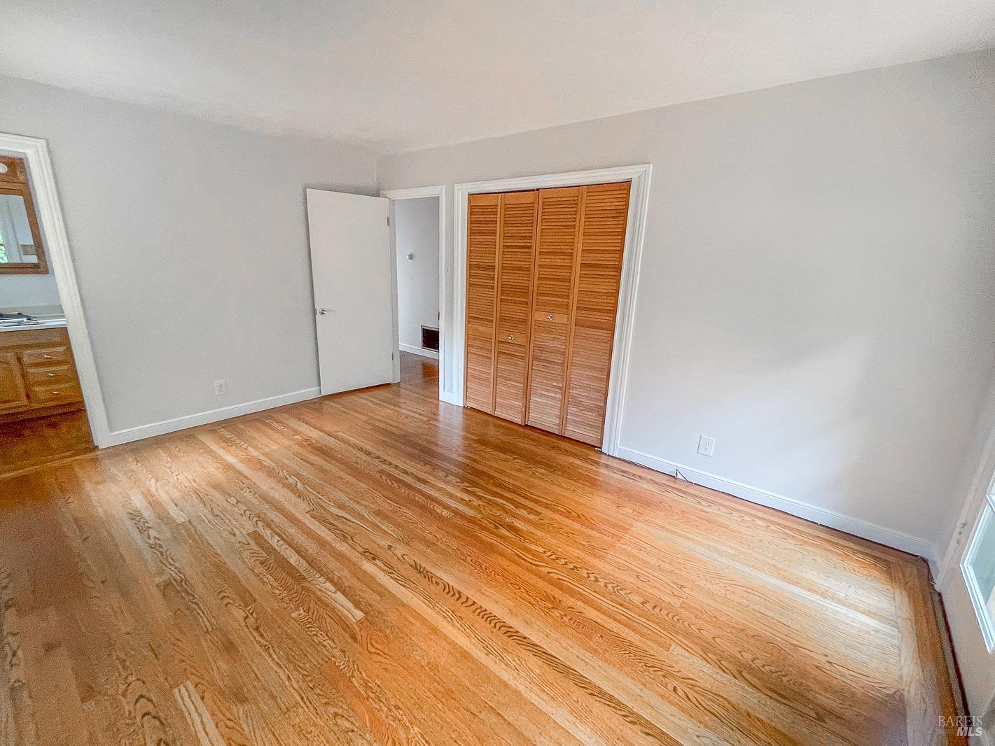 112 Reed Boulevard Mill Valley, CA 94941 - Photo 23 of 39 a view of an empty room with wooden floor and a window