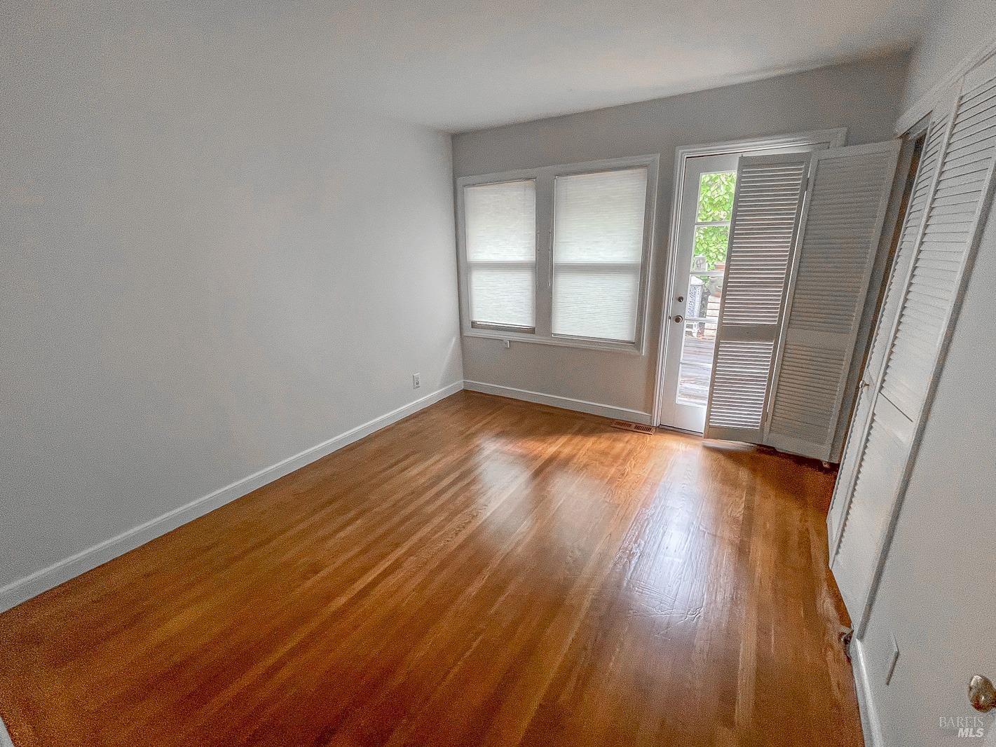 112 Reed Boulevard Mill Valley, CA 94941 - Photo 25 of 39 an empty room with wooden floor and windows