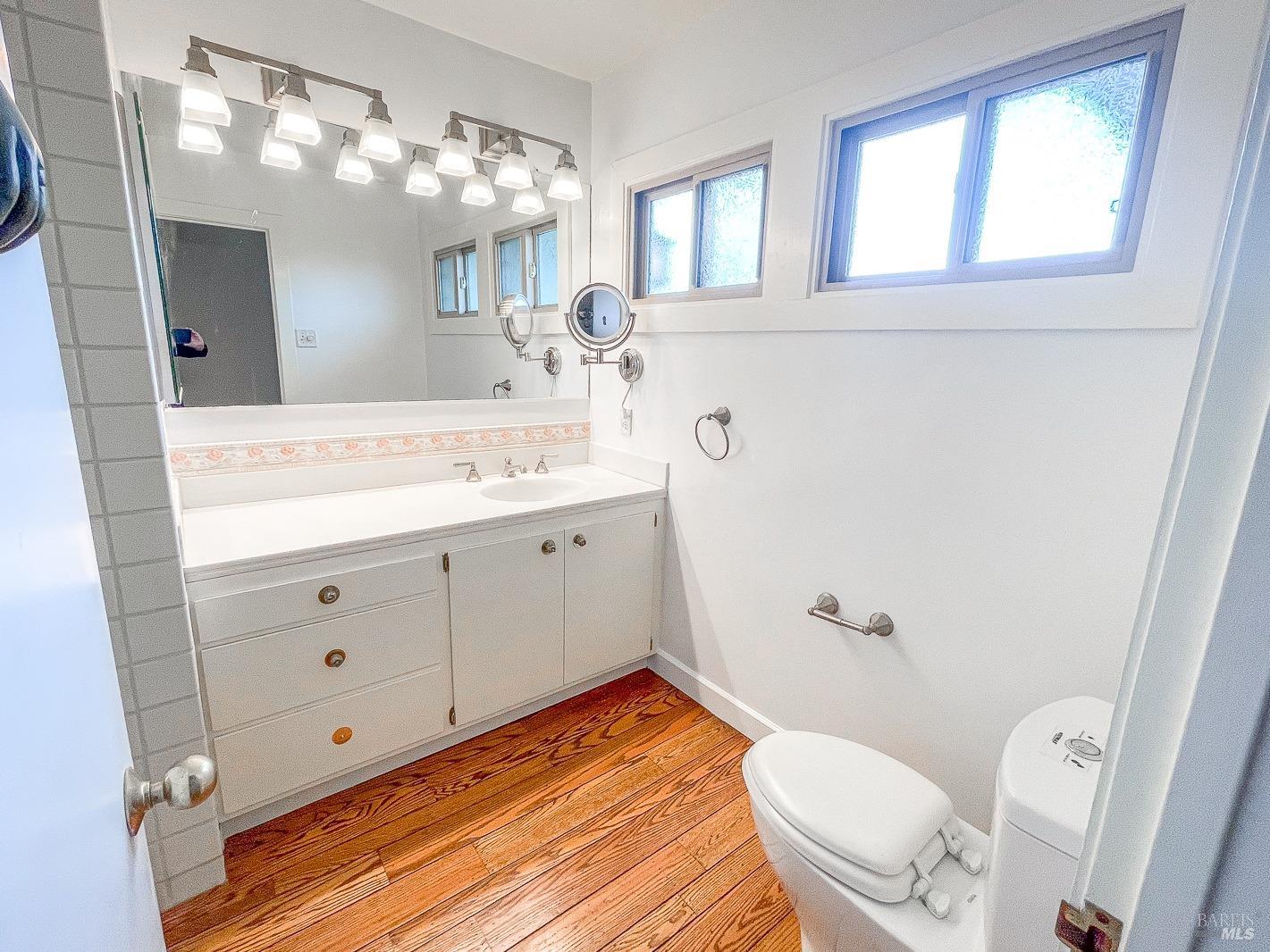 112 Reed Boulevard Mill Valley, CA 94941 - Photo 30 of 39 a bathroom with a sink a mirror a toilet and a window