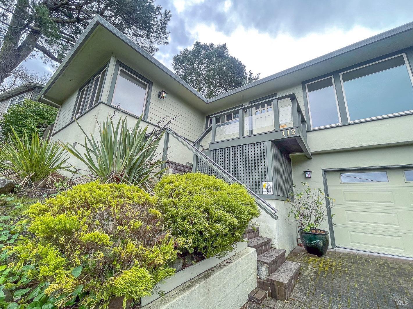 112 Reed Boulevard Mill Valley, CA 94941 - Photo 4 of 39 a yellow house with a flower garden and wooden fence