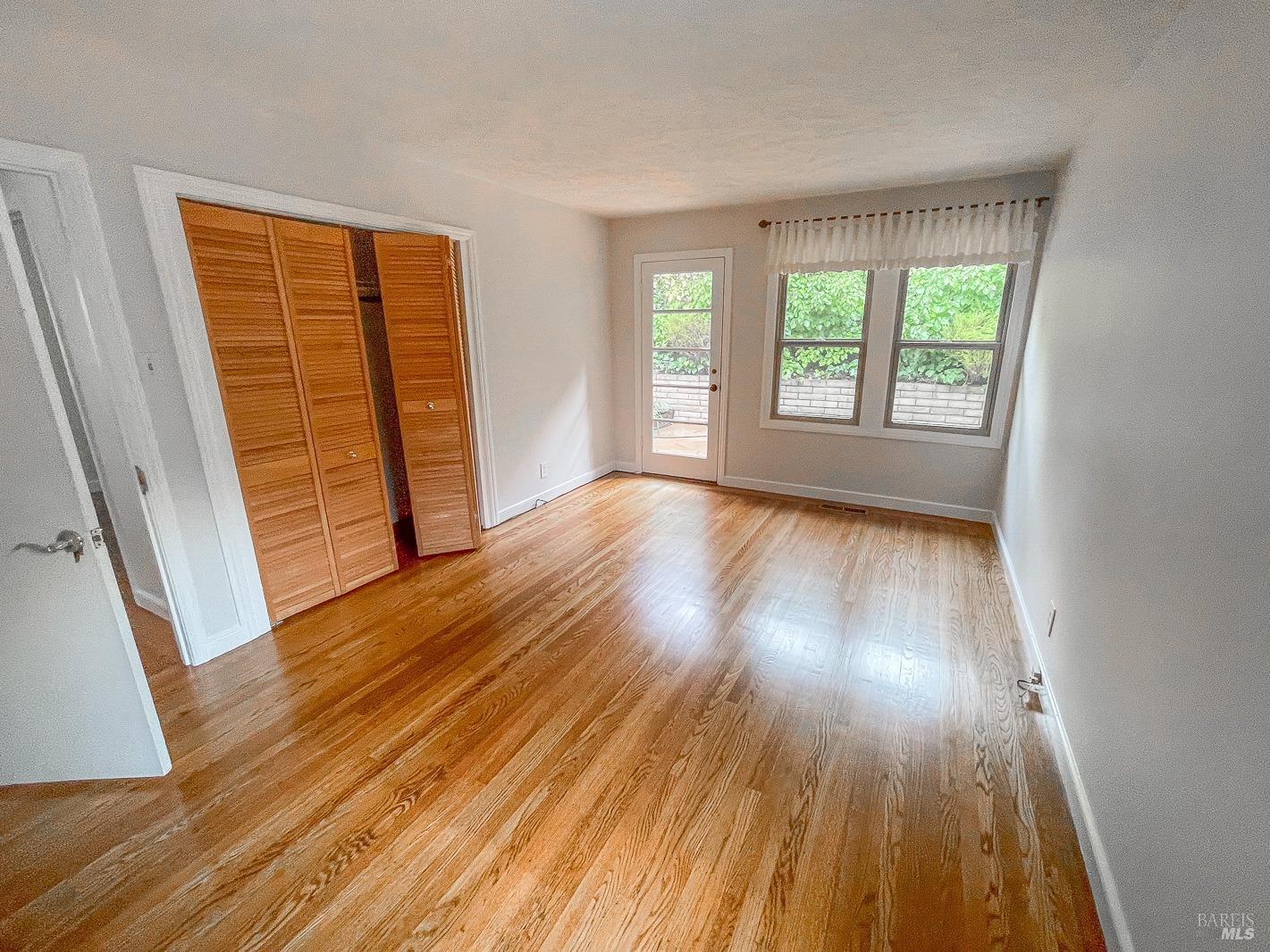 112 Reed Boulevard Mill Valley, CA 94941 - Photo 8 of 39 an empty room with wooden floor and windows