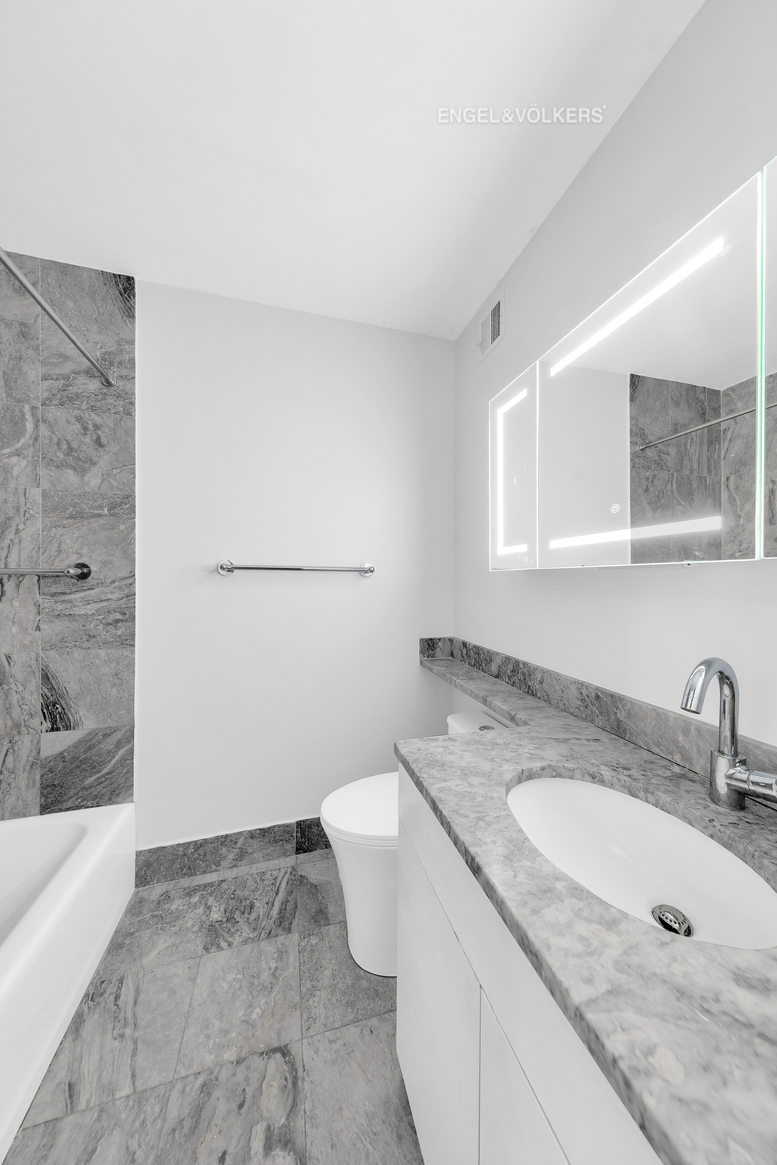 Undisclosed Address Manhattan, NY 10021 - Photo 16 of 18 a bathroom with a granite countertop sink a toilet and bathtub