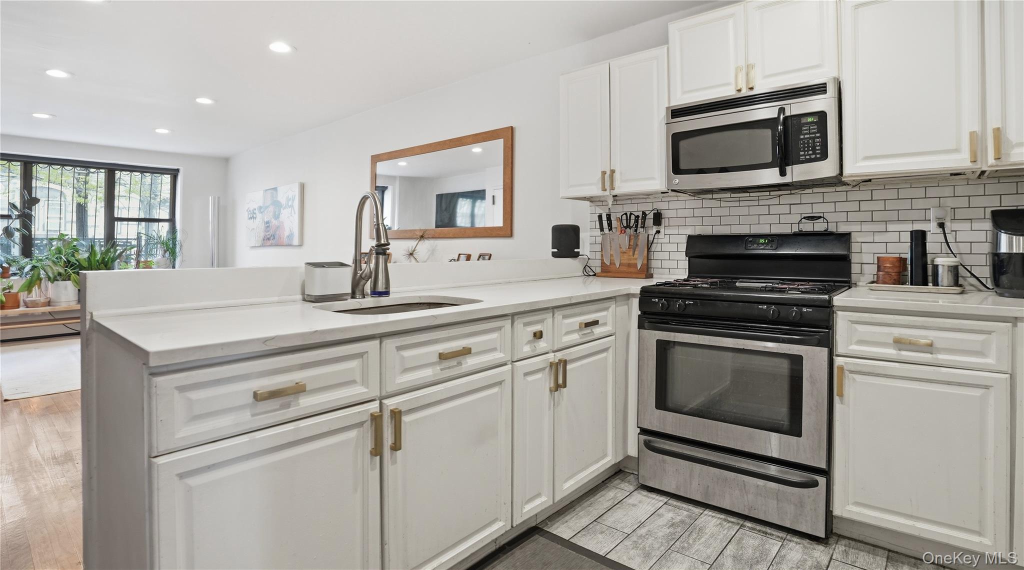 253 Cornelia Street Brooklyn, NY 11221 - Photo 5 of 36 a kitchen with cabinets stainless steel appliances and window