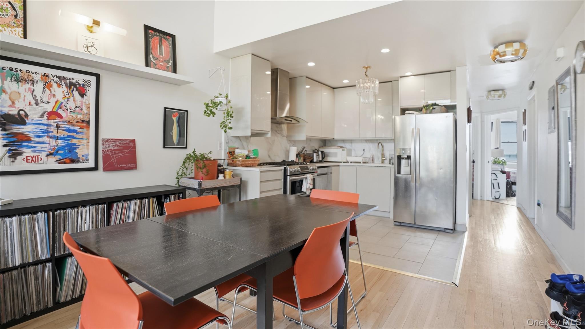 253 Cornelia Street Brooklyn, NY 11221 - Photo 10 of 36 a dining room with stainless steel appliances granite countertop a table chairs and a refrigerator