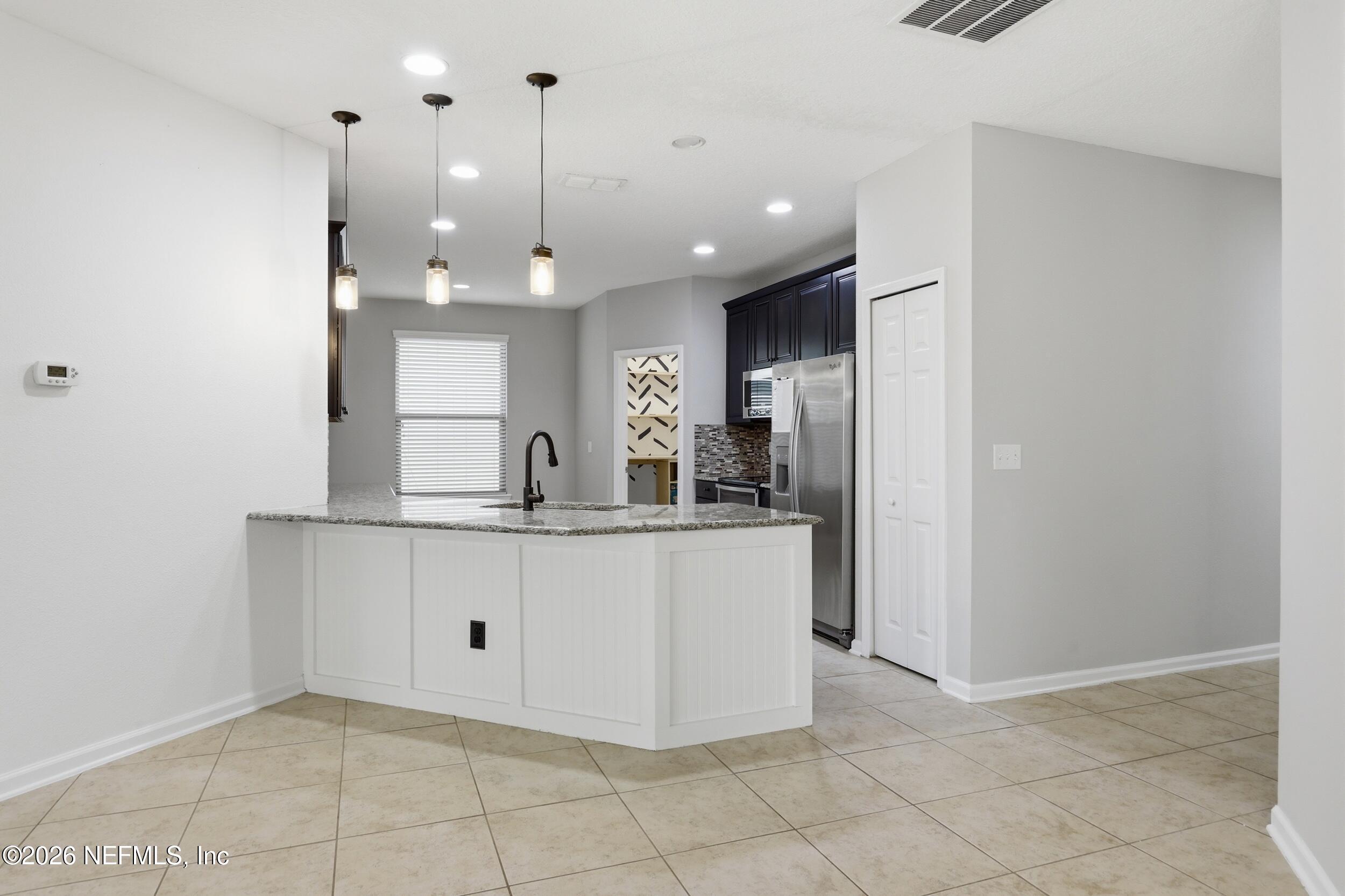 219 Straw Pond Way St. Augustine, FL 32092 - Photo 12 of 36 a view of kitchen with granite countertop cabinets and refrigerator