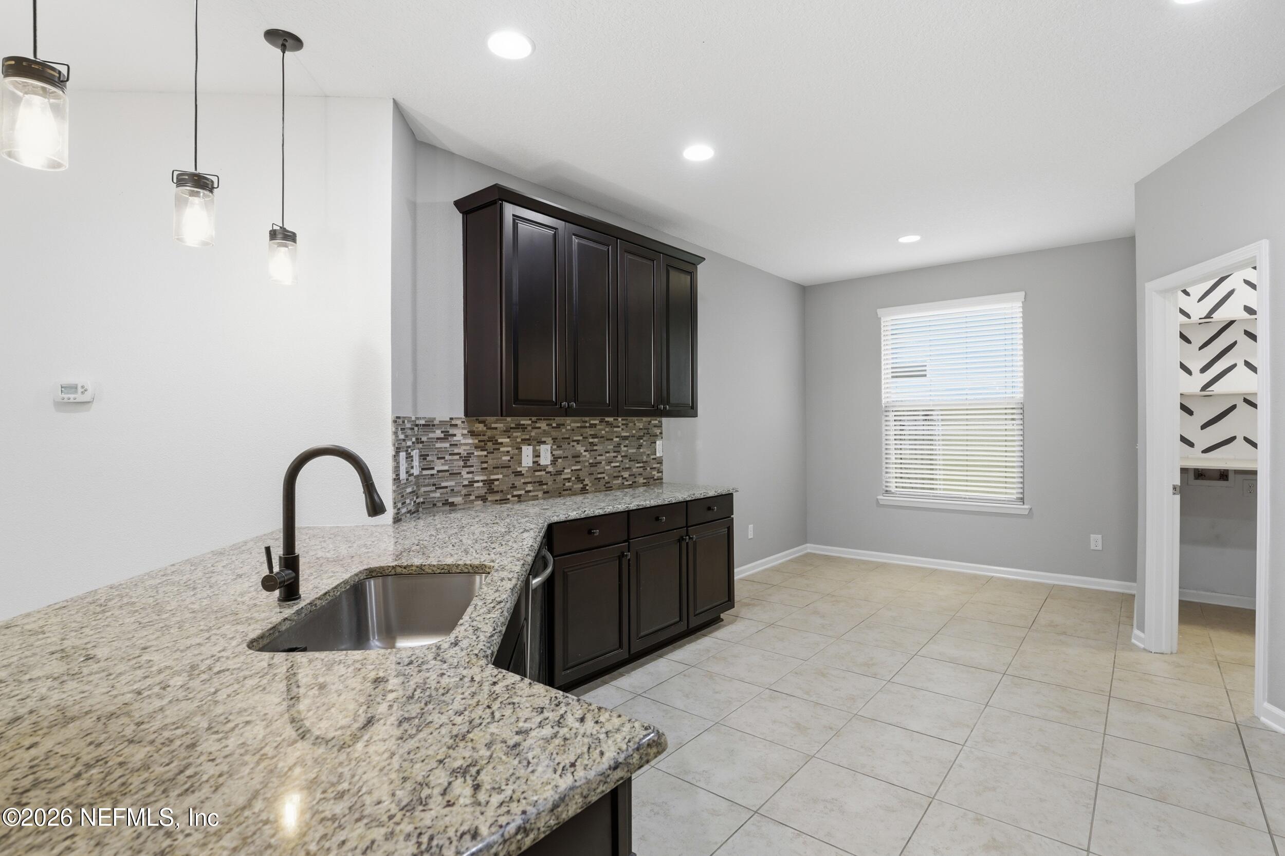 219 Straw Pond Way St. Augustine, FL 32092 - Photo 13 of 36 a kitchen with stainless steel appliances granite countertop a sink a stove and a microwave