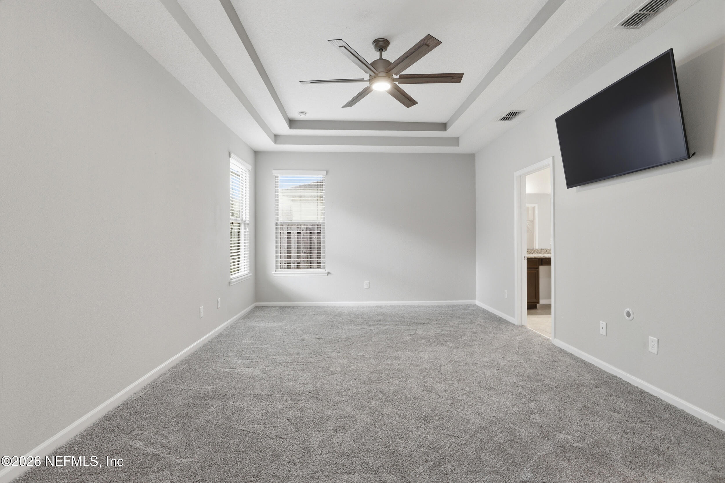 219 Straw Pond Way St. Augustine, FL 32092 - Photo 20 of 36 en empty room with a flat screen tv and a ceiling fan