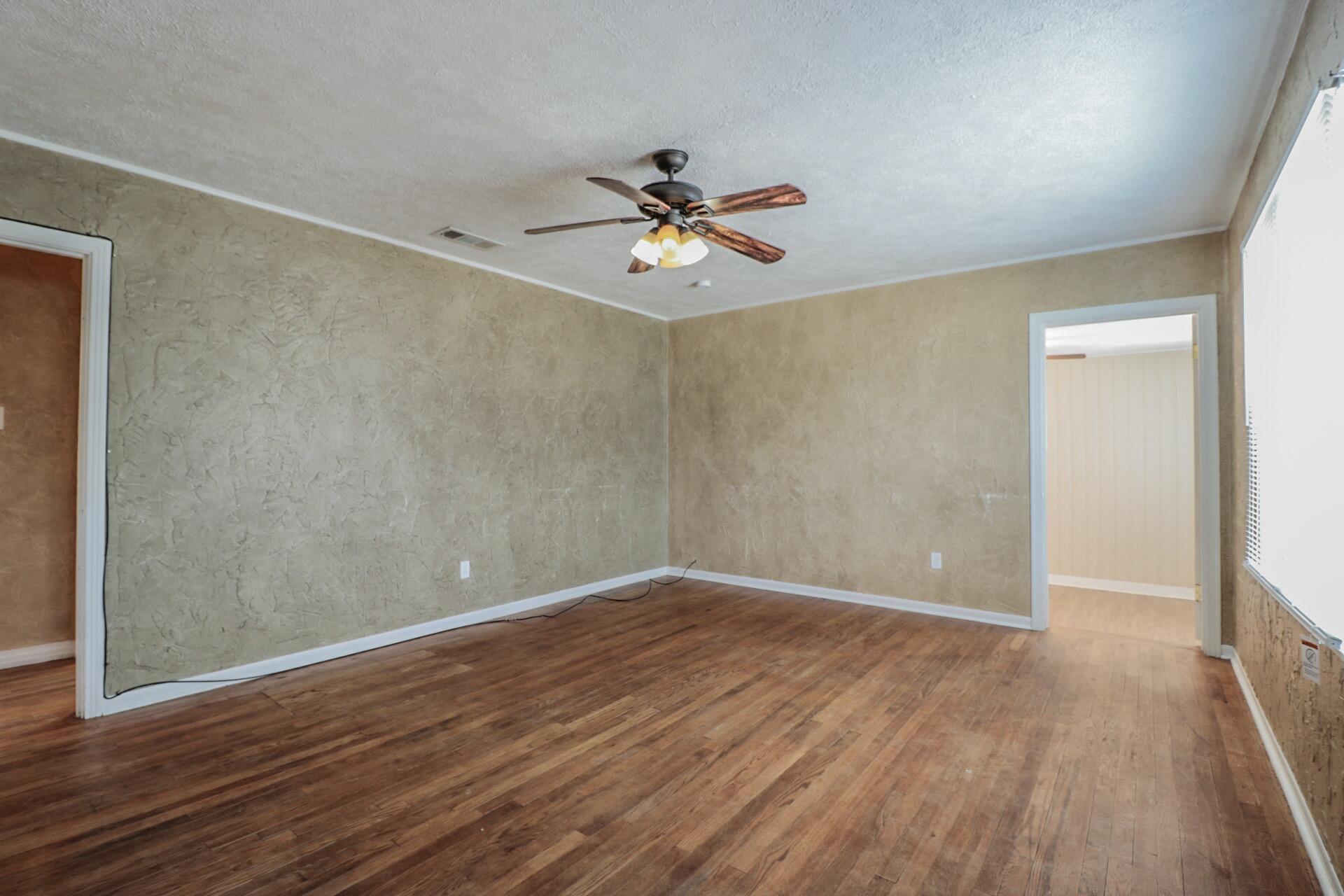 2509 36th Street Lubbock, TX 79413 - Photo 2 of 9 wooden floor in an empty room with a window