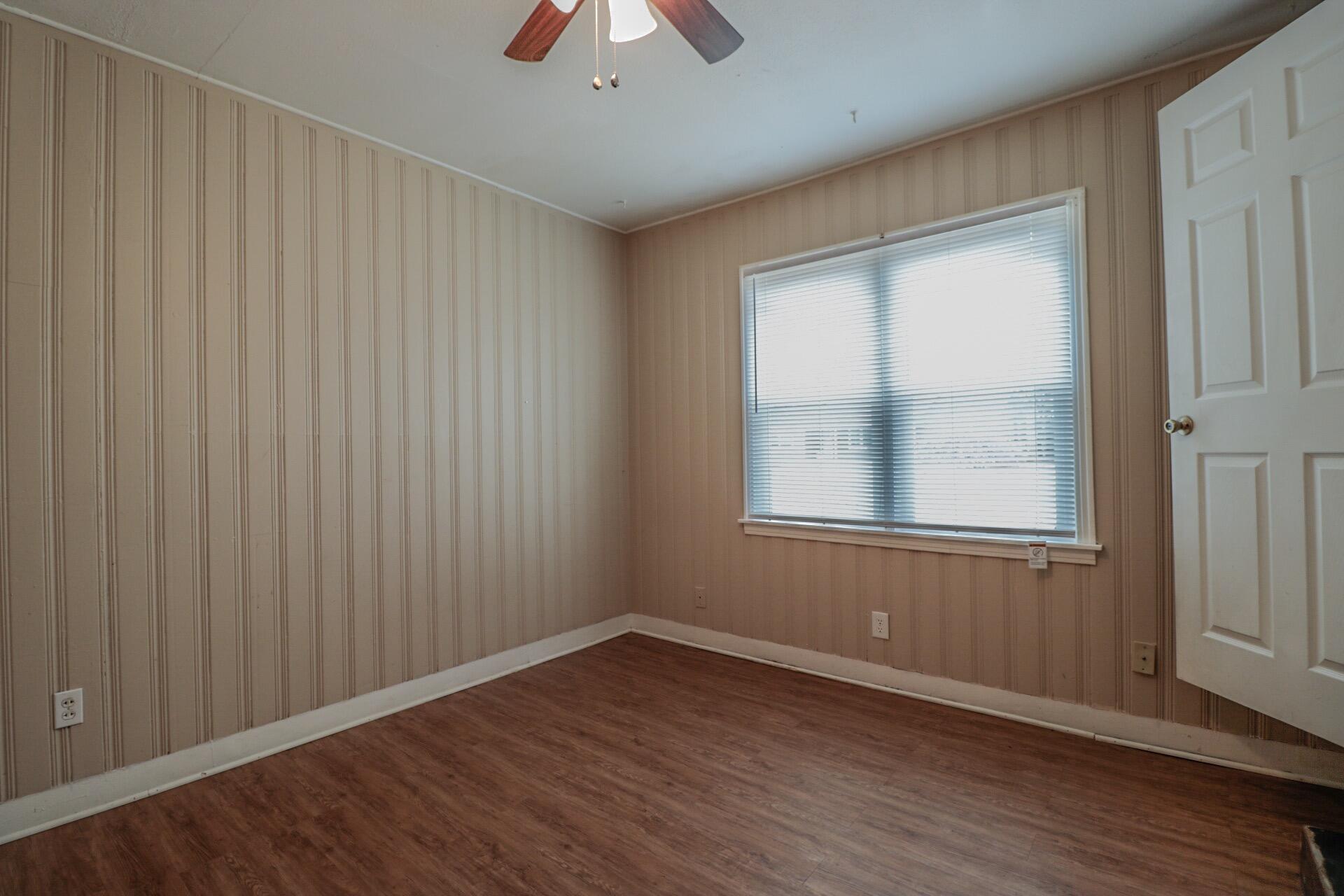 2509 36th Street Lubbock, TX 79413 - Photo 3 of 9 an empty room with wooden floor and windows
