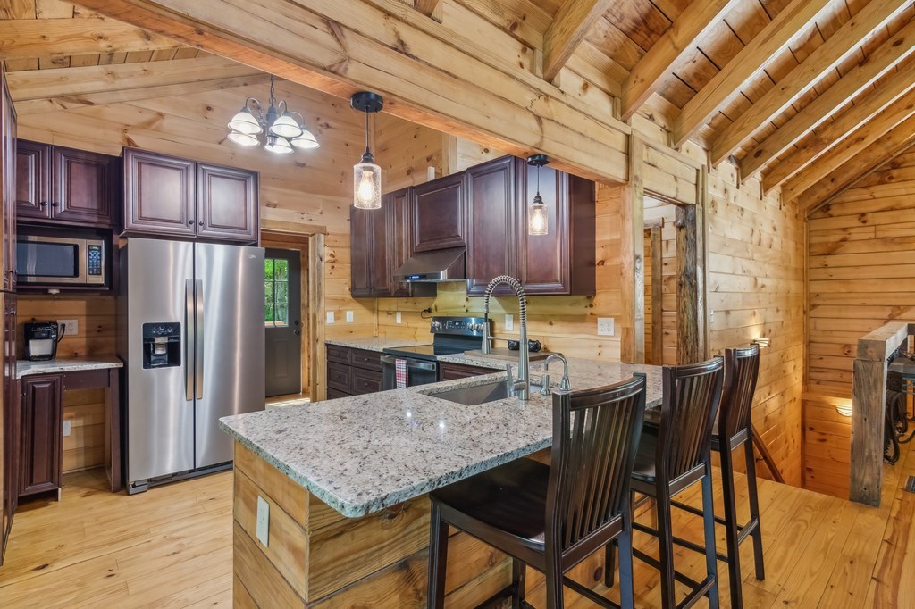 245 Timberwalk Drive Ellijay, GA 30540 - Photo 14 of 56 a kitchen with stainless steel appliances granite countertop a table chairs and a refrigerator