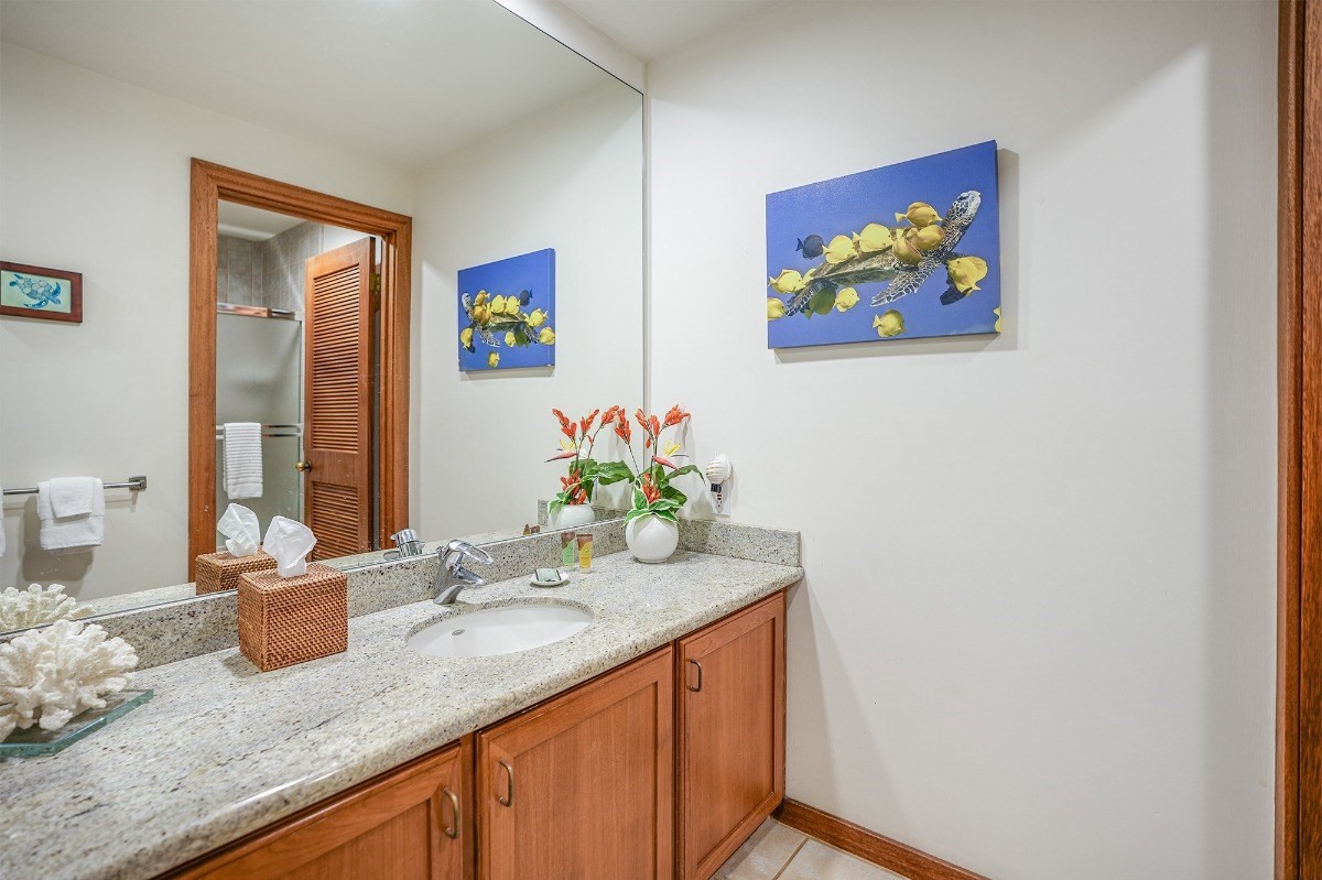 2221 Kapili Road, Unit 58 Koloa, HI 96756 - Photo 19 of 30 a bathroom with a granite countertop sink and a mirror