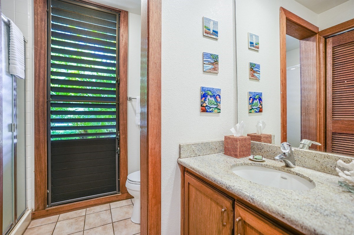 2221 Kapili Road, Unit 58 Koloa, HI 96756 - Photo 20 of 30 a bathroom with a granite countertop sink and a mirror