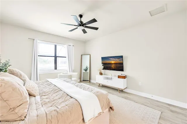 a bedroom with a bed window and a flat screen tv